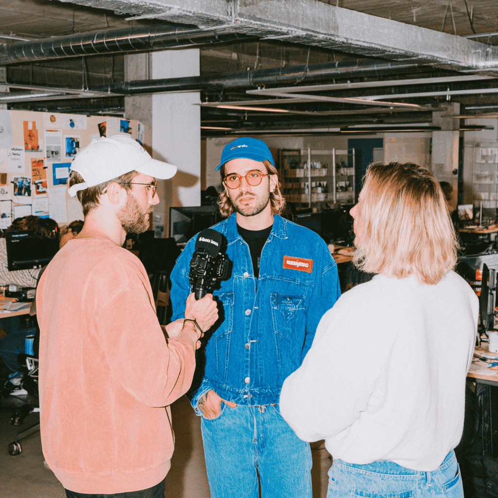 Équipe en tournage vidéo dans un open space créatif, production de contenu vidéo en face caméra
