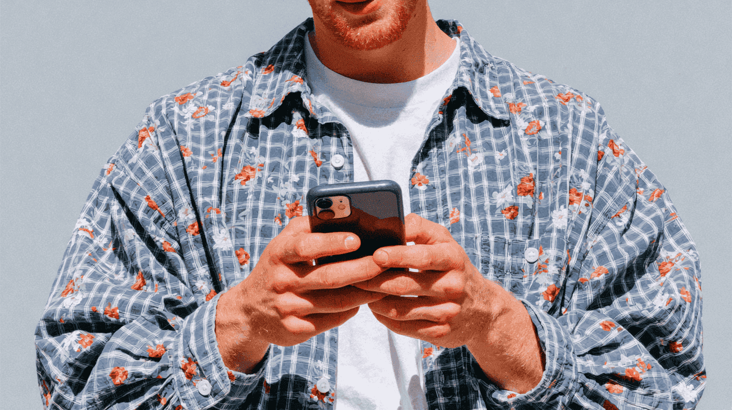 Stratégie social ads : professionnel consultant son fil de réseaux sociaux sur smartphone